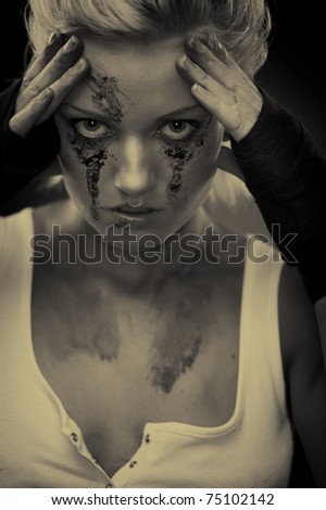 Depressed girl with dirt on her face, closeup. Studio shot, sepia