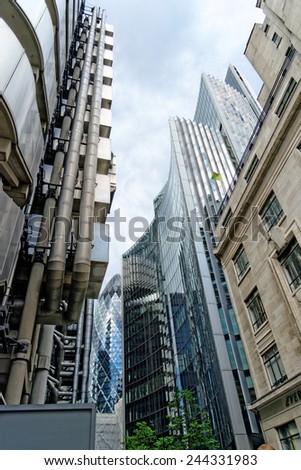 LONDON, UK - JULY 1, 2014: The famous office buildings - The Willis and the Lloyds building the Gherkin Tower in the distance in the City of London, one of the leading centers of global finance.