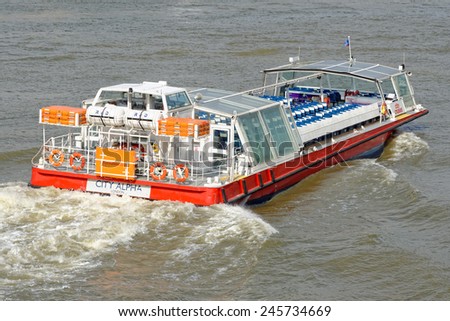 LONDON, UNITED KINGDOM - JULY 1, 2014: A City Cruises tour boat sails on the Thames River. Thames is the longest river in England with 346 km (215 miles) long.