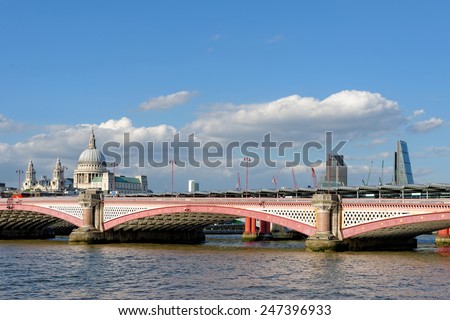 LONDON, UK - JULY 1, 2014: A view of Blackfriars bridge -  a road and foot traffic bridge, over the river Thames against a background of St Paul Cathedral, the City and the Blackfriars railway bridge.