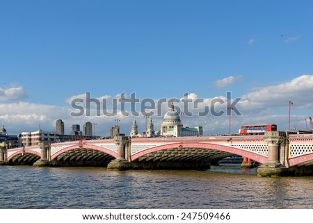 LONDON, UK - JULY 1, 2014: A view of Blackfriars bridge -  a road and foot traffic bridge, over the river Thames against a background of St Paul Cathedral and the residential towers of Barbican.