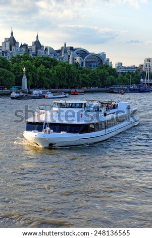 LONDON, UNITED KINGDOM - JULY 1, 2014: A City Cruises tour boat sails on the Thames River near Westminster. Thames is the longest river in England with 346 km in length.