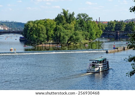 View of the Vltava river and Strelecky island with cruise tour boats from the Charles Bridge. The Charles Bridge is a famous historic bridge that crosses the Vltava river in Prague, Czech Republic.