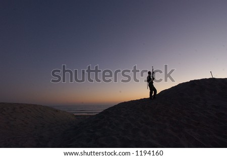 man on hill with gun