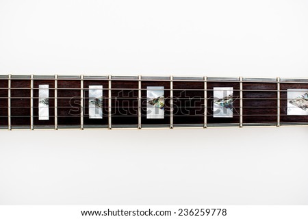 Detail of electric guitar neck and frets on white background