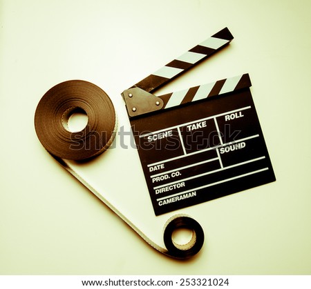 Two 35mm movie reels connected and clapperboard on right side in vintage color effect