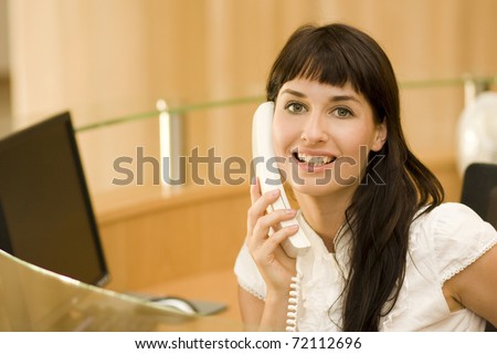 young atractive woman receptionist with phone talking to customers