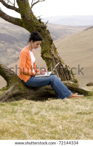 woman using laptop in park and sending e-mail