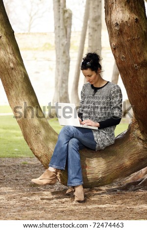 30-35 years old beautiful woman portrait working on laptop computer natural in park
