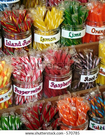 Brightly colored stick candy in clear glass jars.