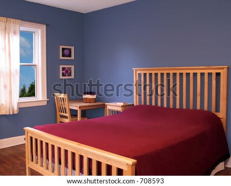 Beautiful bedroom with blue walls and a red bedspread.