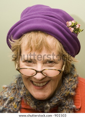 Beautiful older woman wearing a purple hat and red sweater.