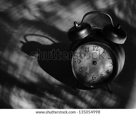 close-up of old broken alarm clock without clock hands on dark background with copy space for your text