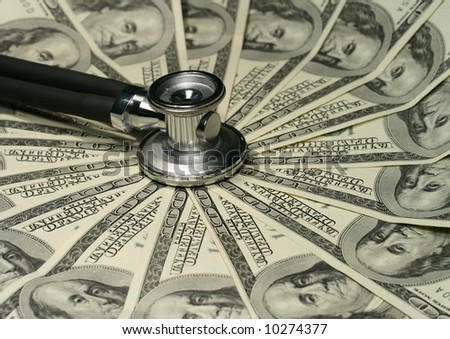 Close-up of stethoscope and one hundred dollars bills