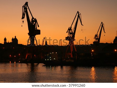Cranes at commercial dock at sunset time (Malta, Maltese islands)