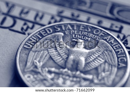 close-up of quarter dollar coin on the one hundred Dollar bill