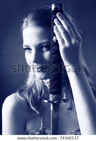 studio shot of Antique clothing young warrior woman holding sword in her hand