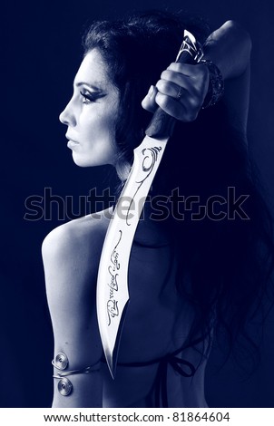 studio shot of young warrior woman holding sword in her hand