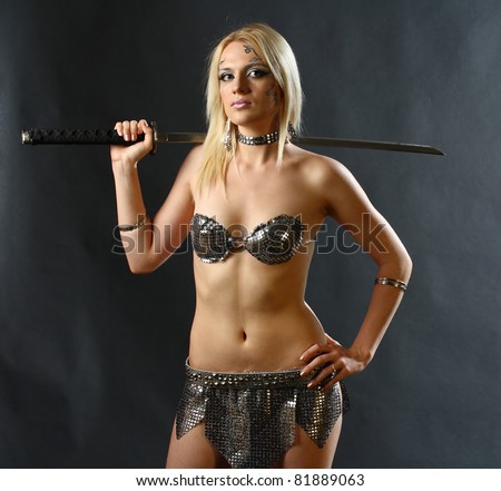 studio shot of young warrior woman holding sword in her hand