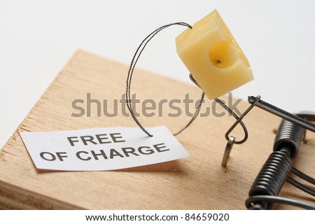 the only free cheese is in the mousetrap: mousetrap with cheese and free sign (free of charge) on the white background