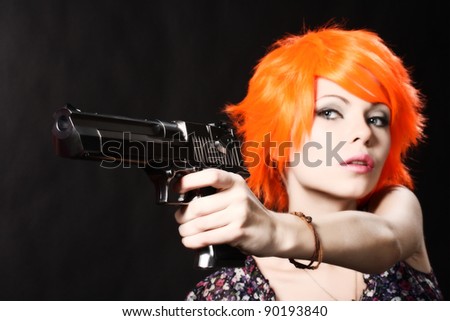studio shot of young foxy woman holding .44 Magnum handgun on black background