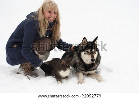winter portrait of young woman with her cat and Eskimo dog on white background