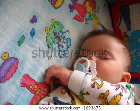 baby sweet dream on colourful blanket;  baby suck teat