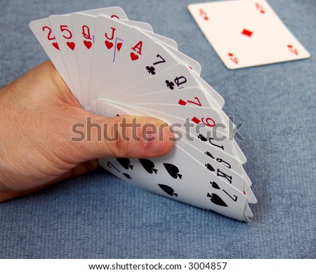 bridge playing - one hand: K,Q,J,7 spade, A,Q,J,5,2 heart, 9,7 diamond, Q,7 club, background open one card ace diamond on blue