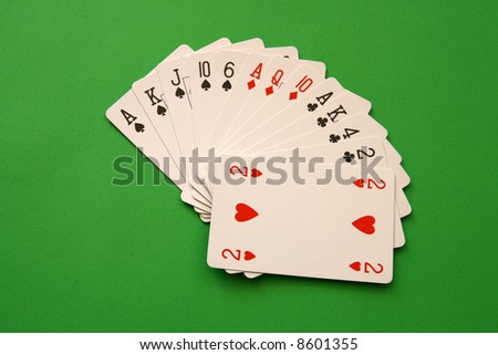 bridge playing - one hand (A,K,J,10,6 spades, 2 heart, A,Q,10 diamonds, A,K,4,2 clubs)  background green,
