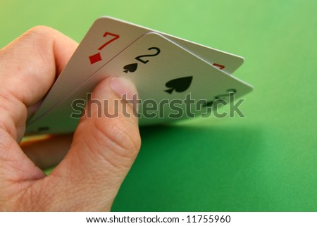 7 diamond and 2 spade (bad cards) in the hand on green background...
