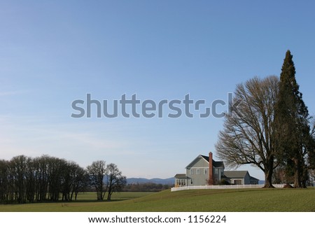 House with picket fence overlooking field