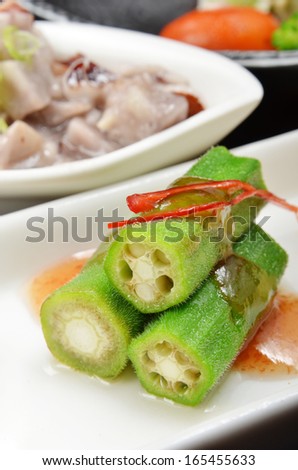 Okra with  sauce on white plate