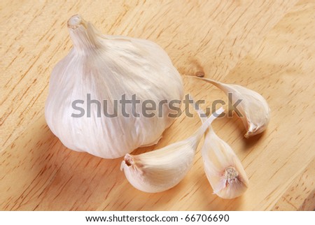 Garlic with slice on wood board closeup
