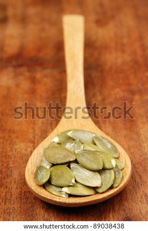 Pumpkin seeds on a wood spoon