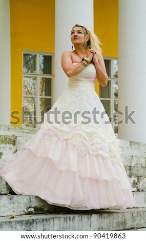 Blonde girl in the image of a medieval lady in a gorgeous dress of the old manor near Moscow