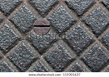 Metal Grid - Diamond shapes on metal grid with a round rusted rusted screw head