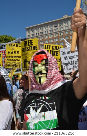 HOLLYWOOD, CA - AUGUST 16, 2014: A protestor wears a Guy Fawkes mask and holds a flagpole during a protest against Israeli military actions in Gaza on August 16, 2014 in Hollywood, California.