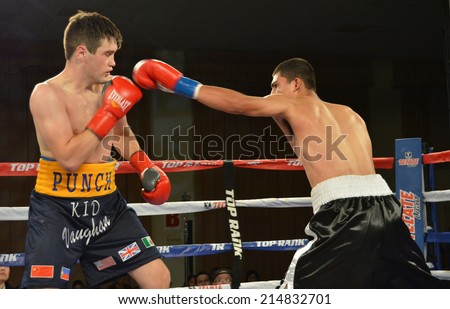 GLENDALE, CA - AUGUST 9, 2014: Boxer Saul Benitez extends his left arm, throwing a punch at opponent Liam Vaughn at the Glendale Fight Night in Glendale, California on August 9, 2014.