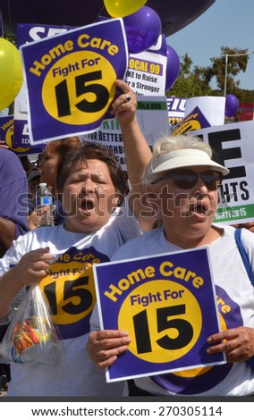 LOS ANGELES, CA  APRIL 15, 2015: Protestors shout and display signs advocating raising the minimum wage for home health care workers during a demonstration in Los Angeles on April 15, 2015.