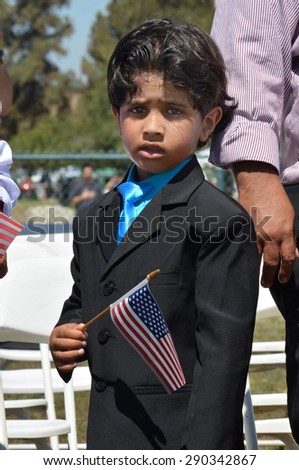 LAKE VIEW TERRACE, CA â?? JUNE 20, 2015: A young boy holds an American flag as he prepares to become a U.S. citizen during a public naturalization ceremony in Lake View Terrace, CA on June 20, 2015.