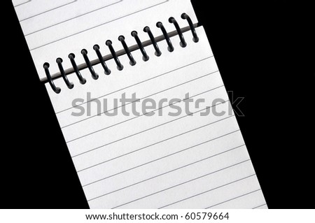 Note Book -- A small notebook, spiral bound on the top, sits open revealing a blank page on a clean black background.