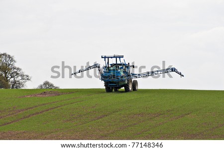 agricultural tractor with chemical treatment spraying equipment opening or retracting