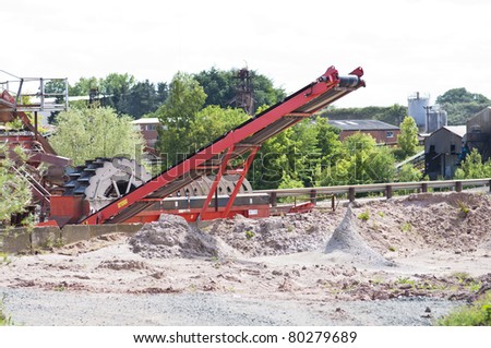 heavy conveyor belt and grading and digging equipment at a sand and gravel quarry