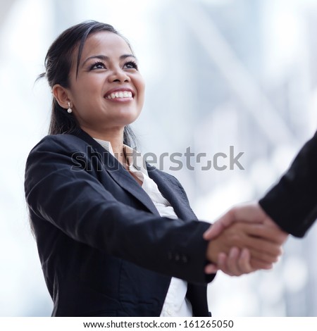 Business woman giving a handshake and smiling