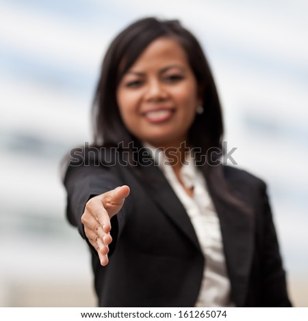 Business woman giving a handshake and smiling