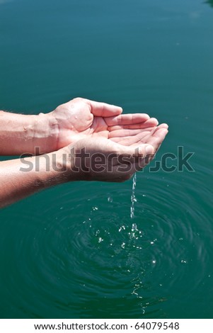 Human hands splashing pure water from river