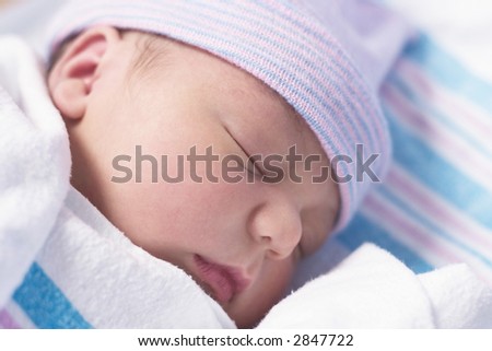 Newborn baby boy in hospital nursery resting peacefully