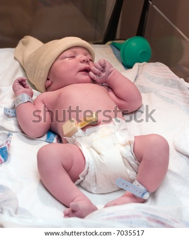 Newborn baby boy resting in hospital post-delivery room