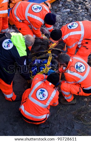 BUSSOLENO, ITALY- DECEMBER 9: Red Cross during rescue mission on December, 9, 2011 in Bussoleno, Italy. The rescue workers  move hurt person with a stretcher