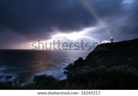 lighthouse at the time of dramatic stormy sunset